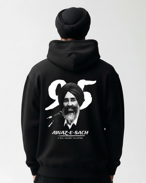 Person wearing a black hoodie with a graphic and text on the back, on a plain background